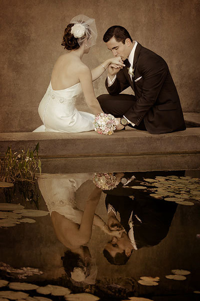 bride and groom reflected on the water