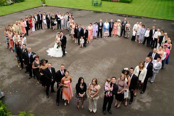 wedding guests surrounding the couple in a heart