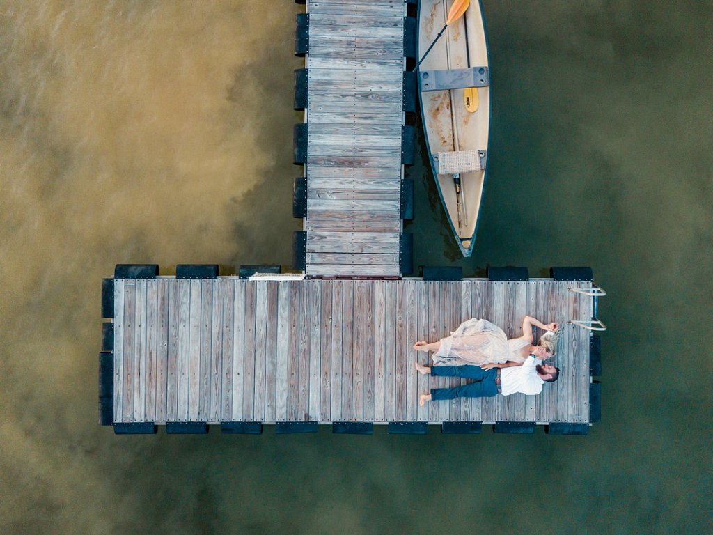 Bride and groom on a lake dock