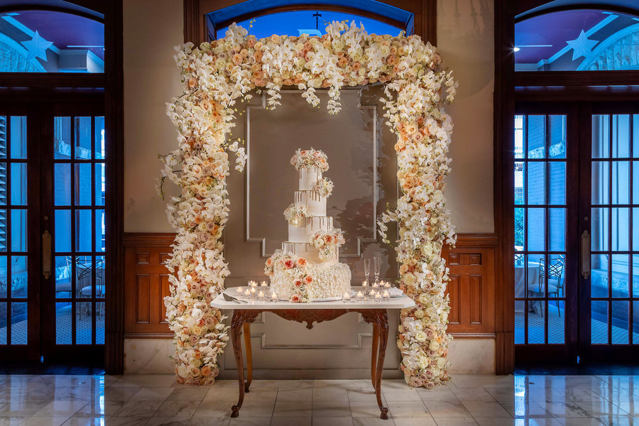 Floral arch over wedding cake