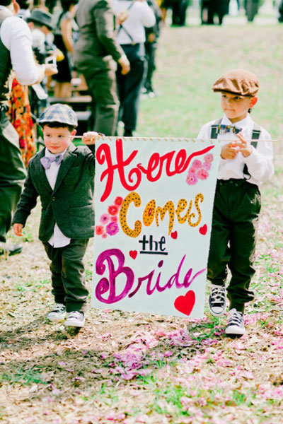 two ring bearers holding a sign