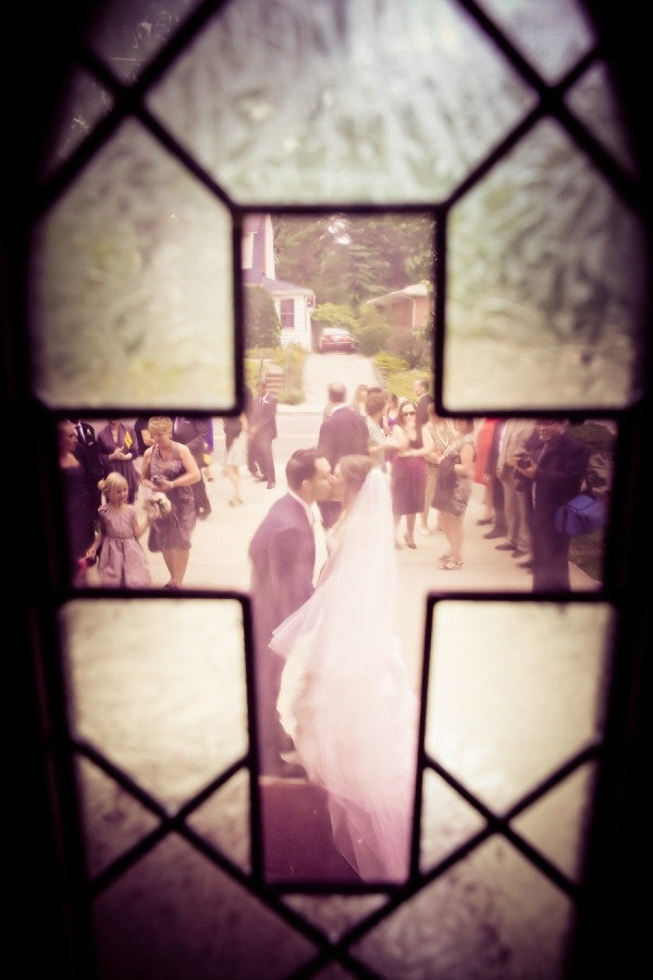 wedding photo through the church stained glass window