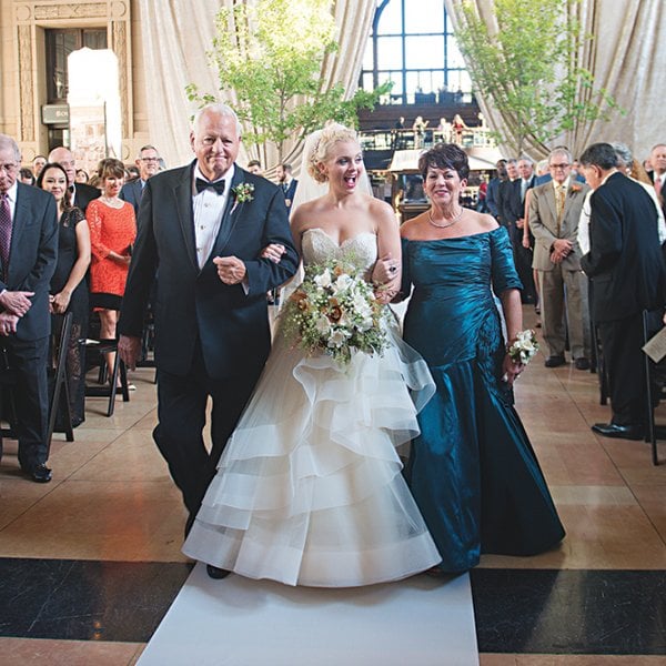 bride walking down the aisle with parents