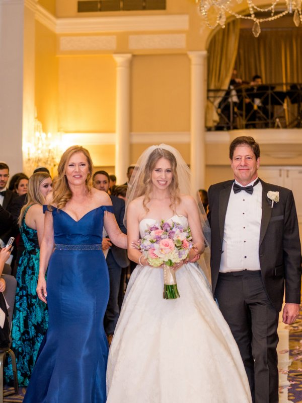 Bride walking down the aisle with parents
