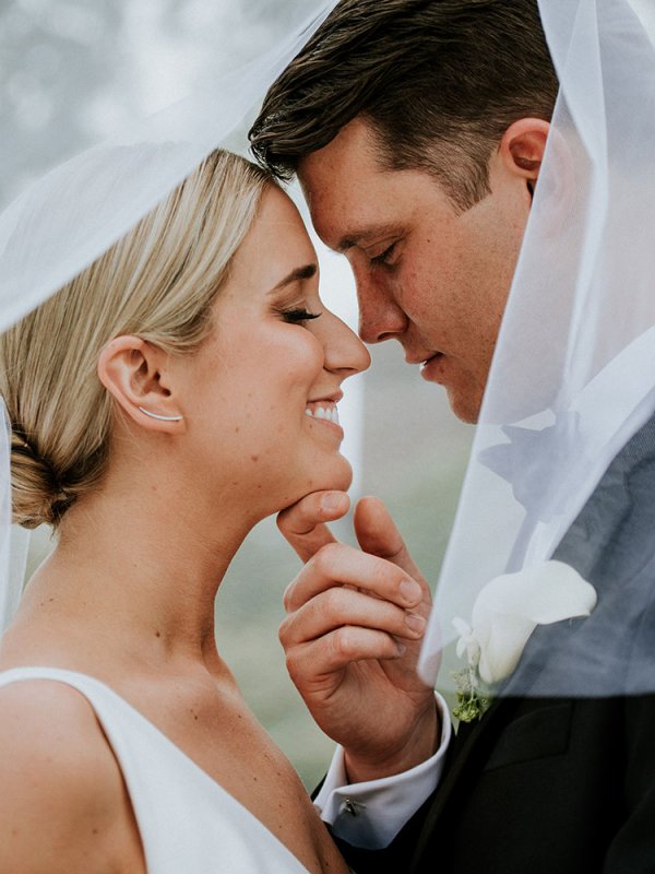 Bride and Groom Kissing Under Veil