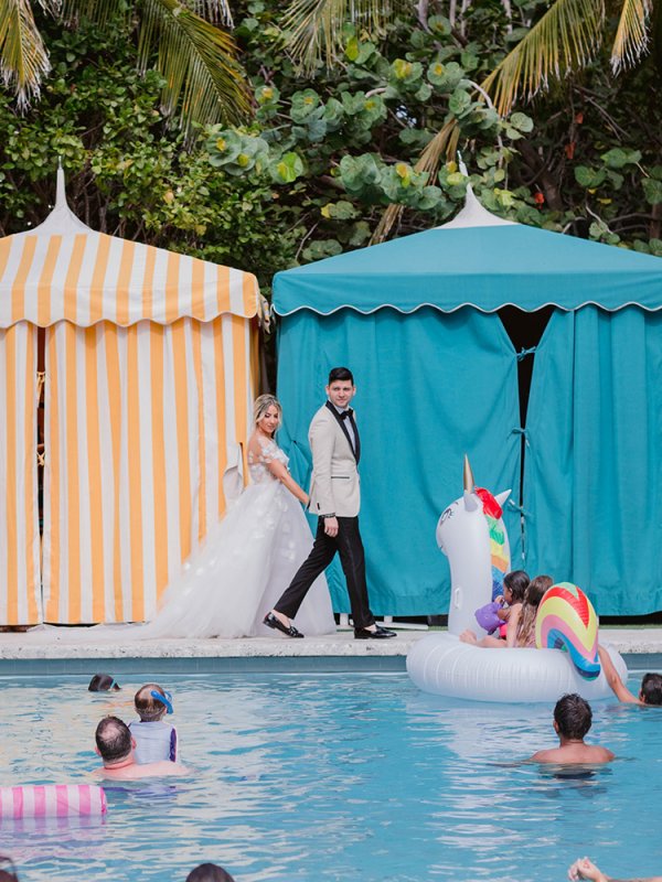 Bride and groom walking around a pool