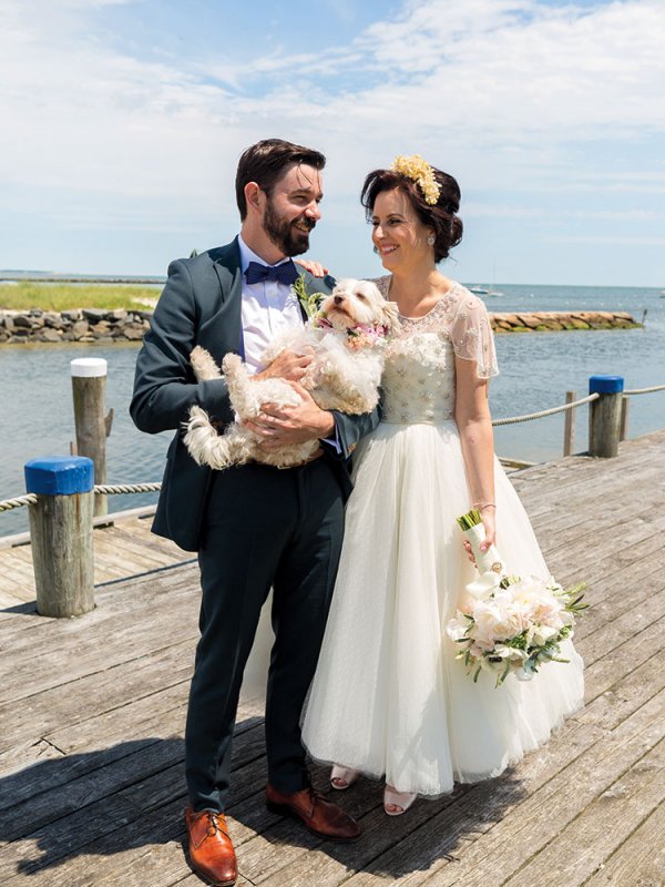 Bride and groom with dog on a pier