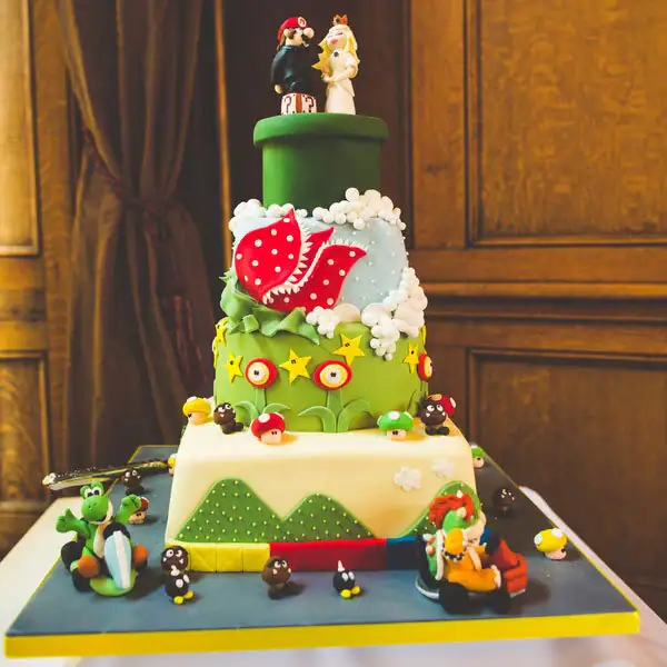 A colorful, multi-tiered wedding cake decorated with Super Mario characters and themes.