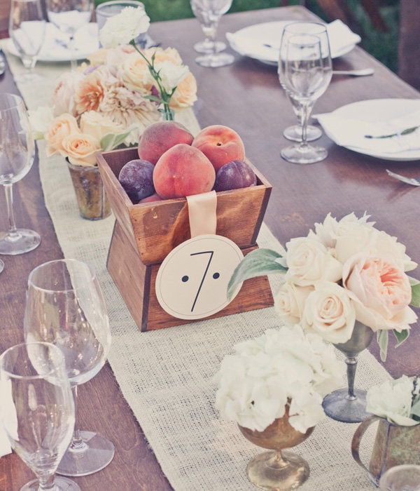 Elegant wedding table centerpiece with fresh peaches and roses.