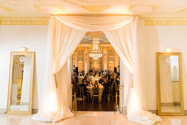 Elegant wedding reception with draped curtains and chandelier lighting, perfect for timeless wedding.