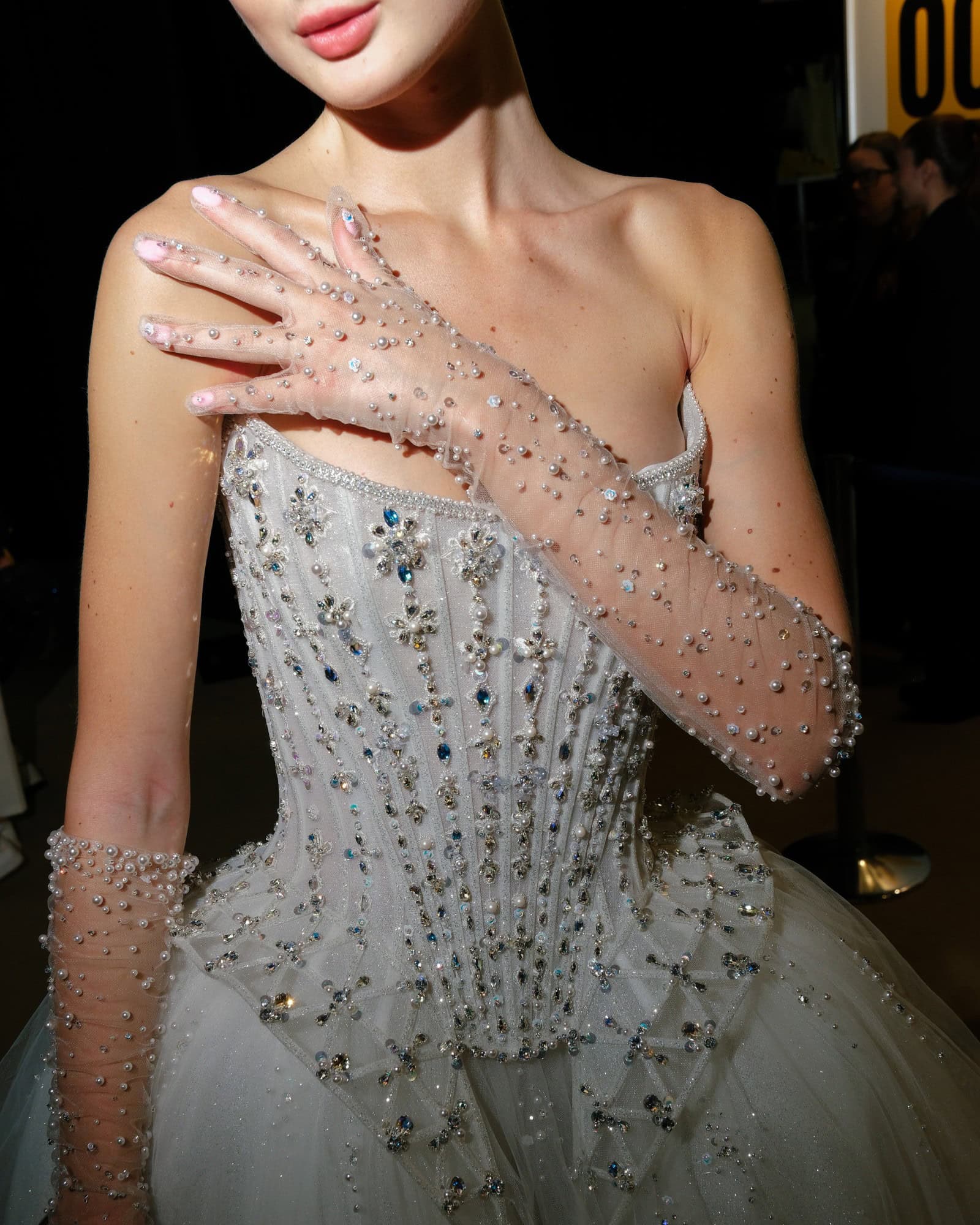 Elegant bridal gown with beaded details and matching sheer gloves for a wedding look.