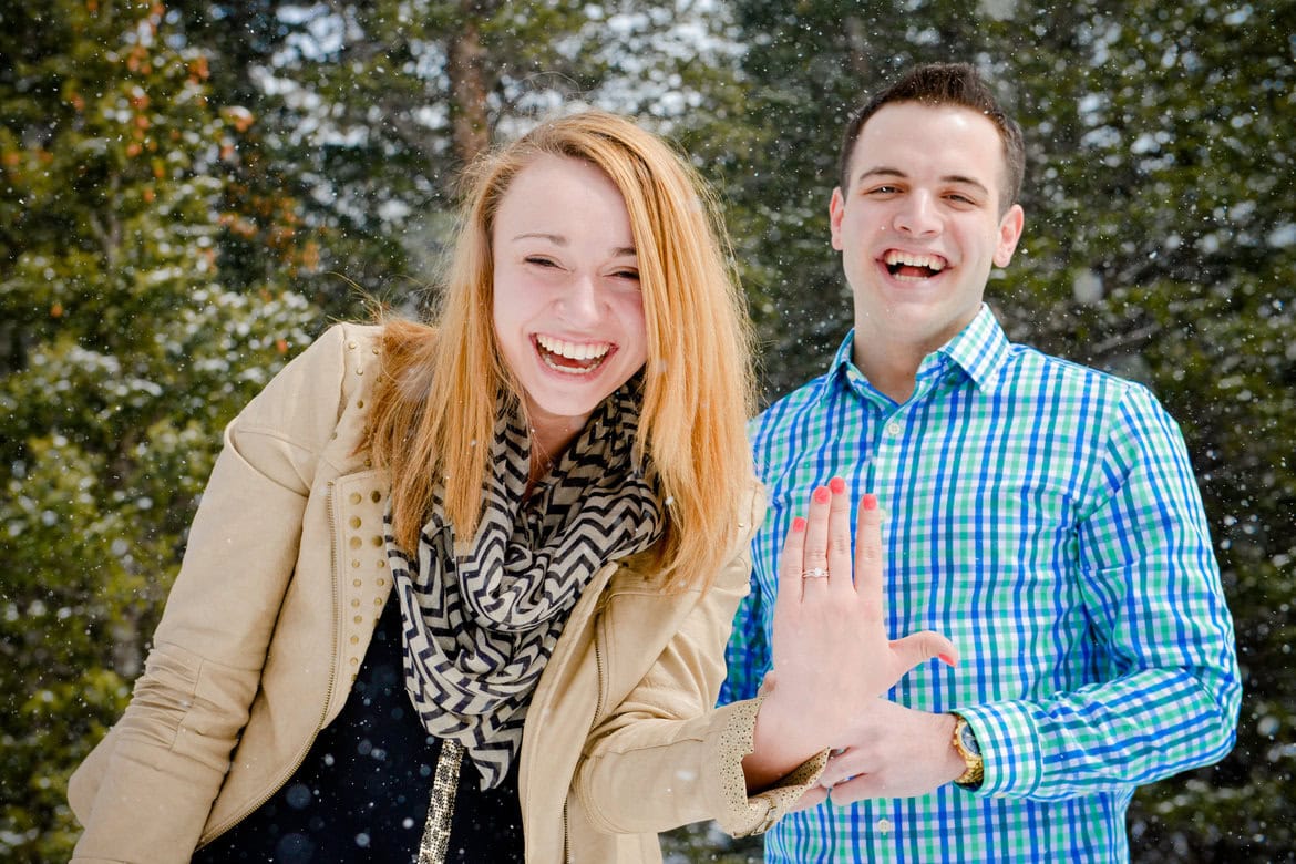 A joyful couple celebrating outdoors with a playful high-five, wedding planning fun.
