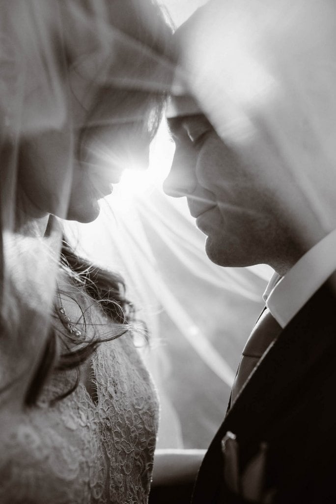 A couple sharing an intimate moment on their wedding day, close-up black and white photo.