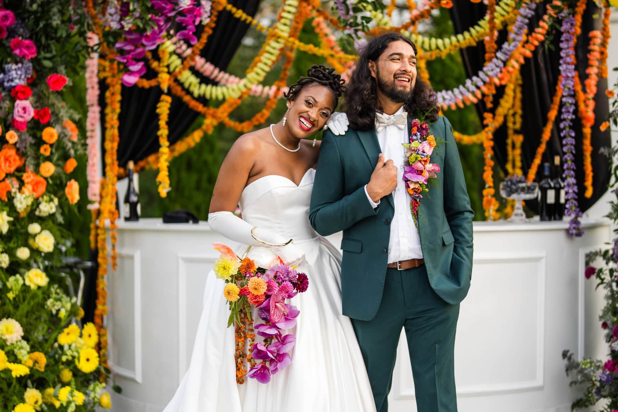 Happy bride and groom celebrating wedding with colorful floral decorations.