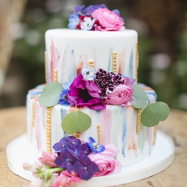 A colorful wedding cake with fresh flowers and elegant design for bridal celebration.