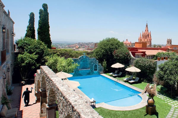 Luxury rooftop pool with city view and historic architecture in the background.