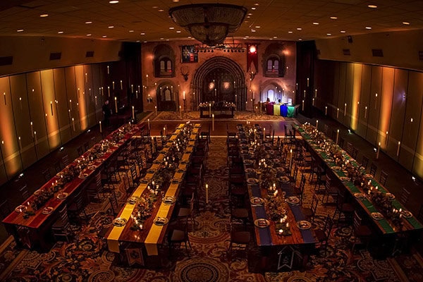 Elegant banquet hall with long decorated tables for wedding reception or event.