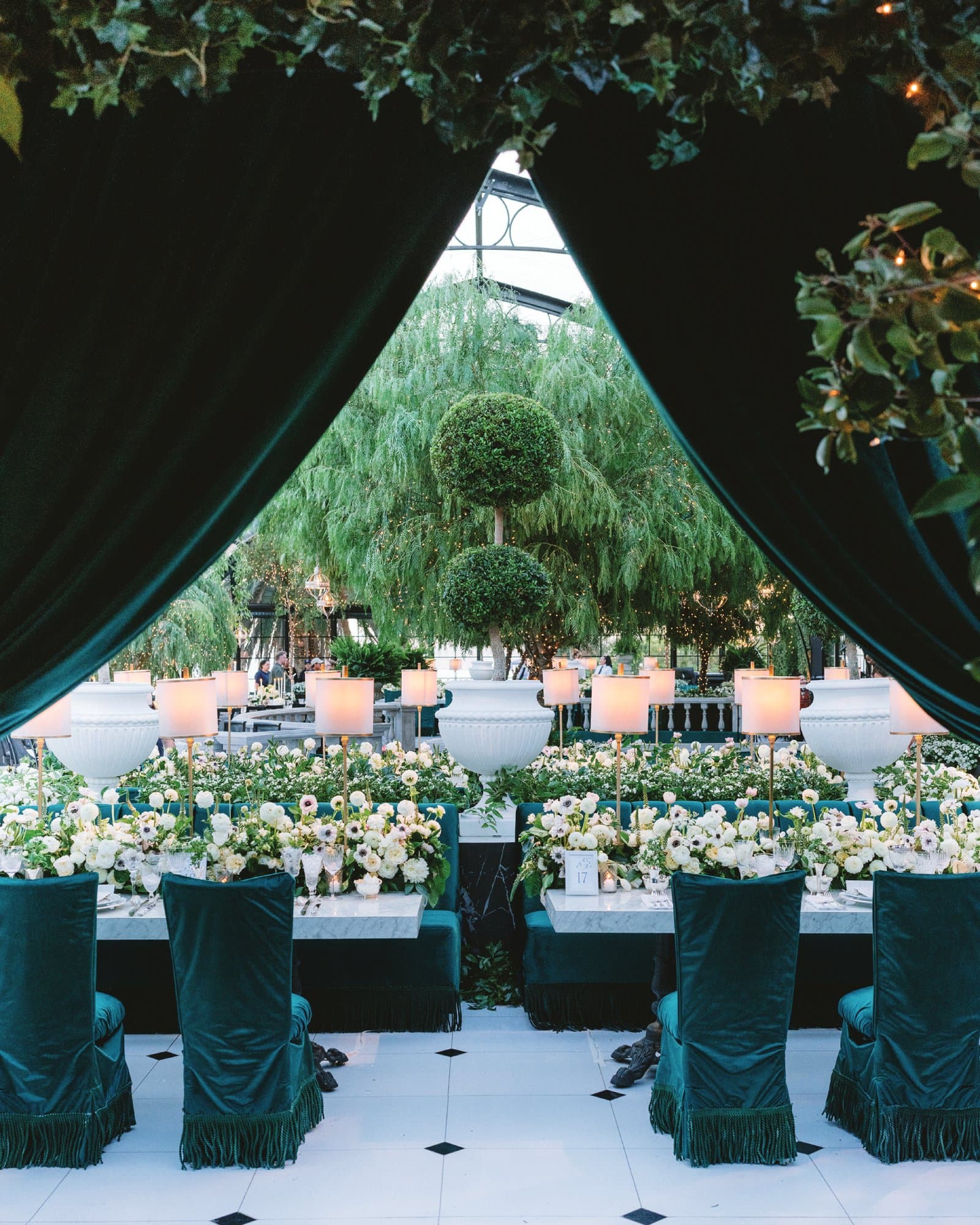 Elegant outdoor wedding reception with lush greenery and floral decor.