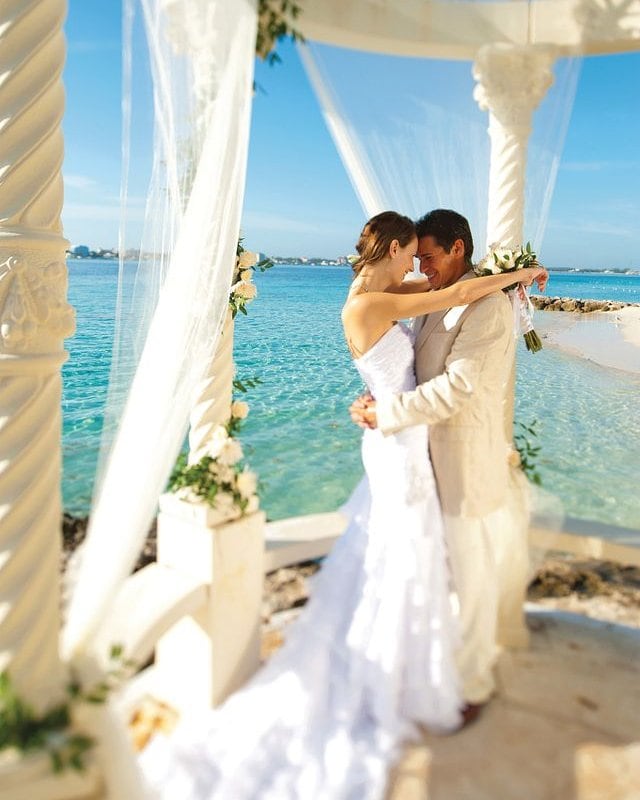 Bride and groom share a dance at a Caribbean beach wedding ceremony with ocean view.